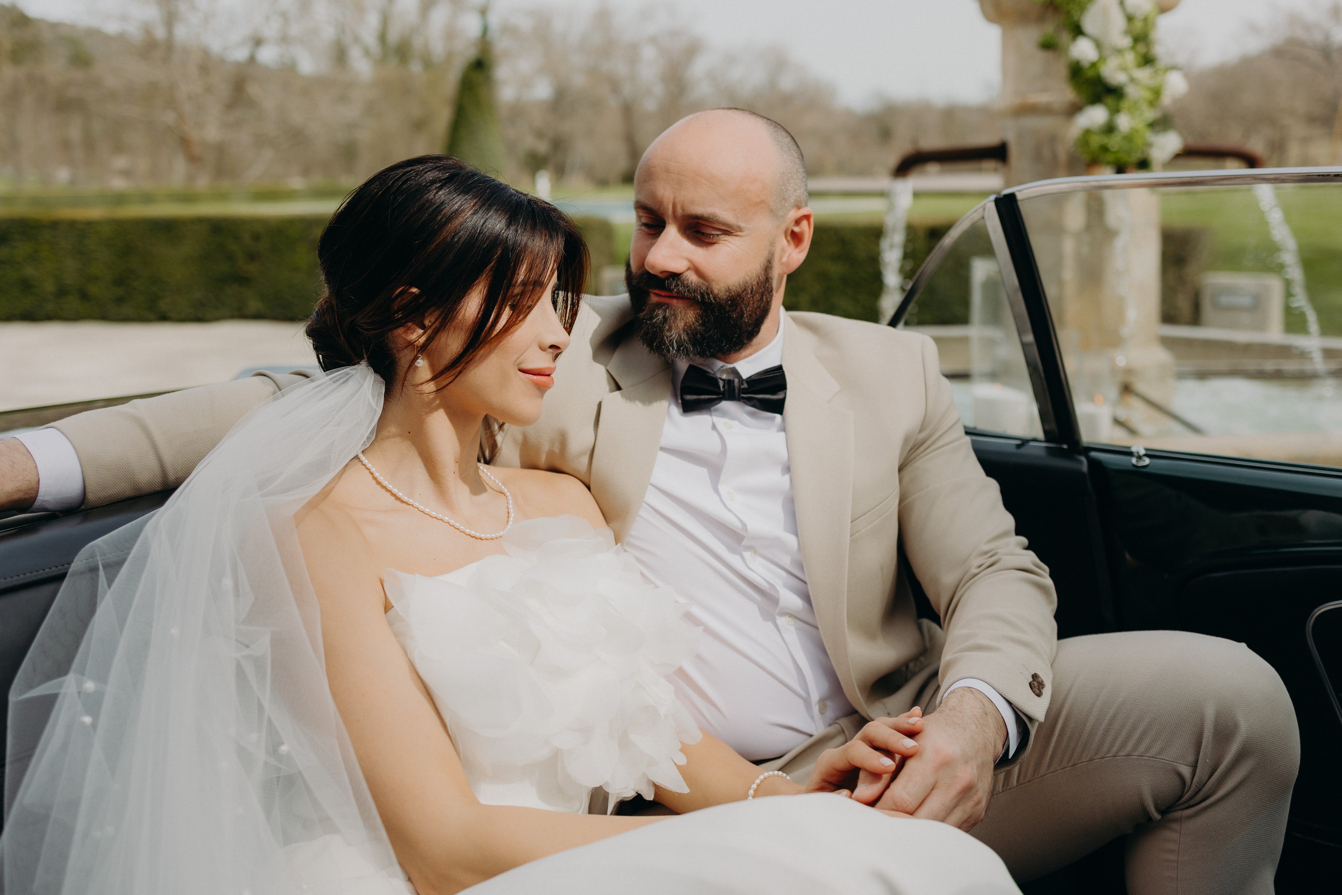 Les mariés souriants dans leur voiture, entourés d’une ambiance chaleureuse et naturelle, avec une décoration élégante aux tons matcha et olive, parfaite pour une inspiration mariage moderne et naturel.