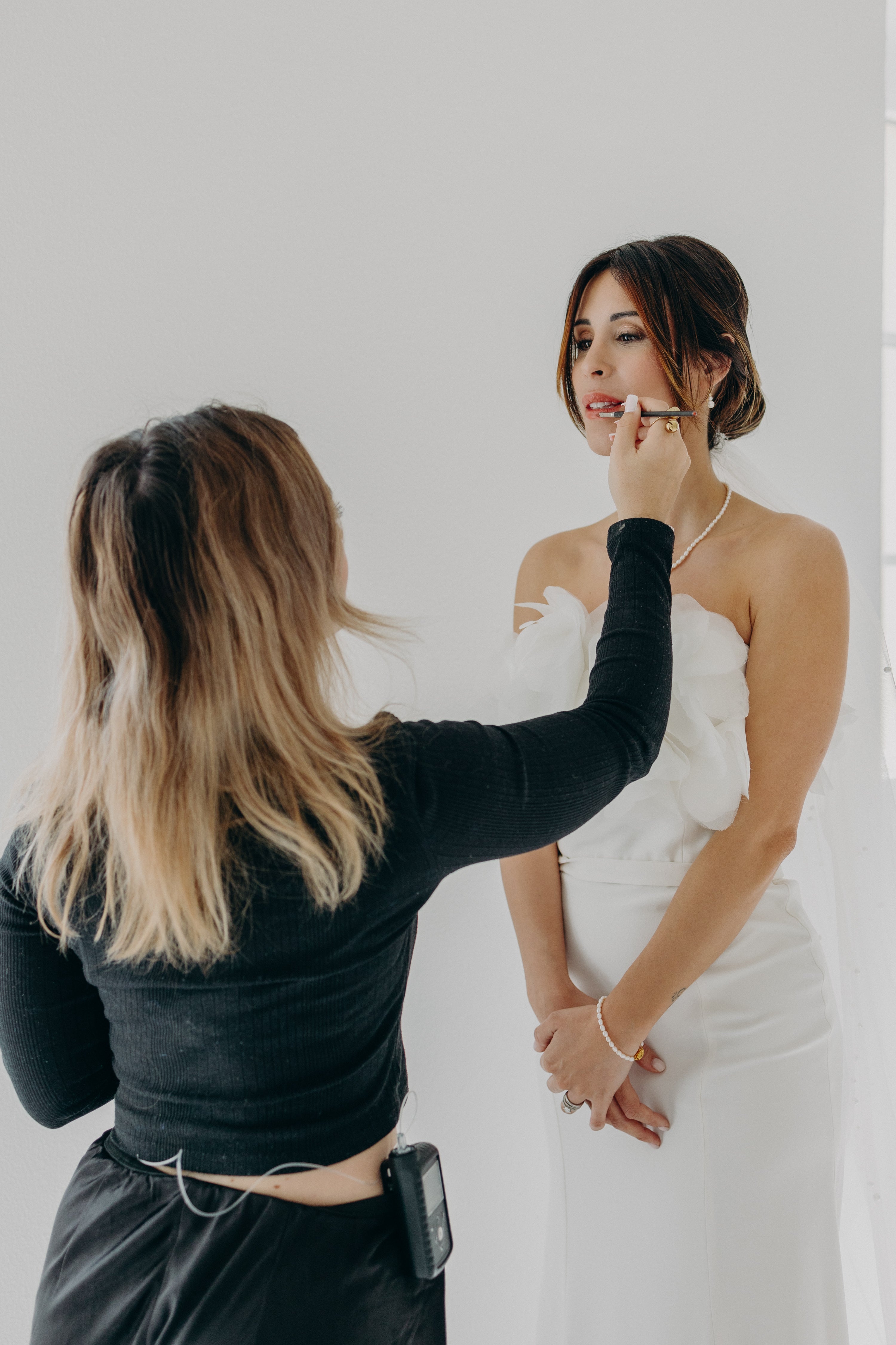 La mariée se fait maquiller avec soin, dans une ambiance douce et naturelle, en harmonie avec un mariage moderne et naturel aux tons matcha et olive, sublimée par des bijoux Atelier Lilac artisanaux et poétiques