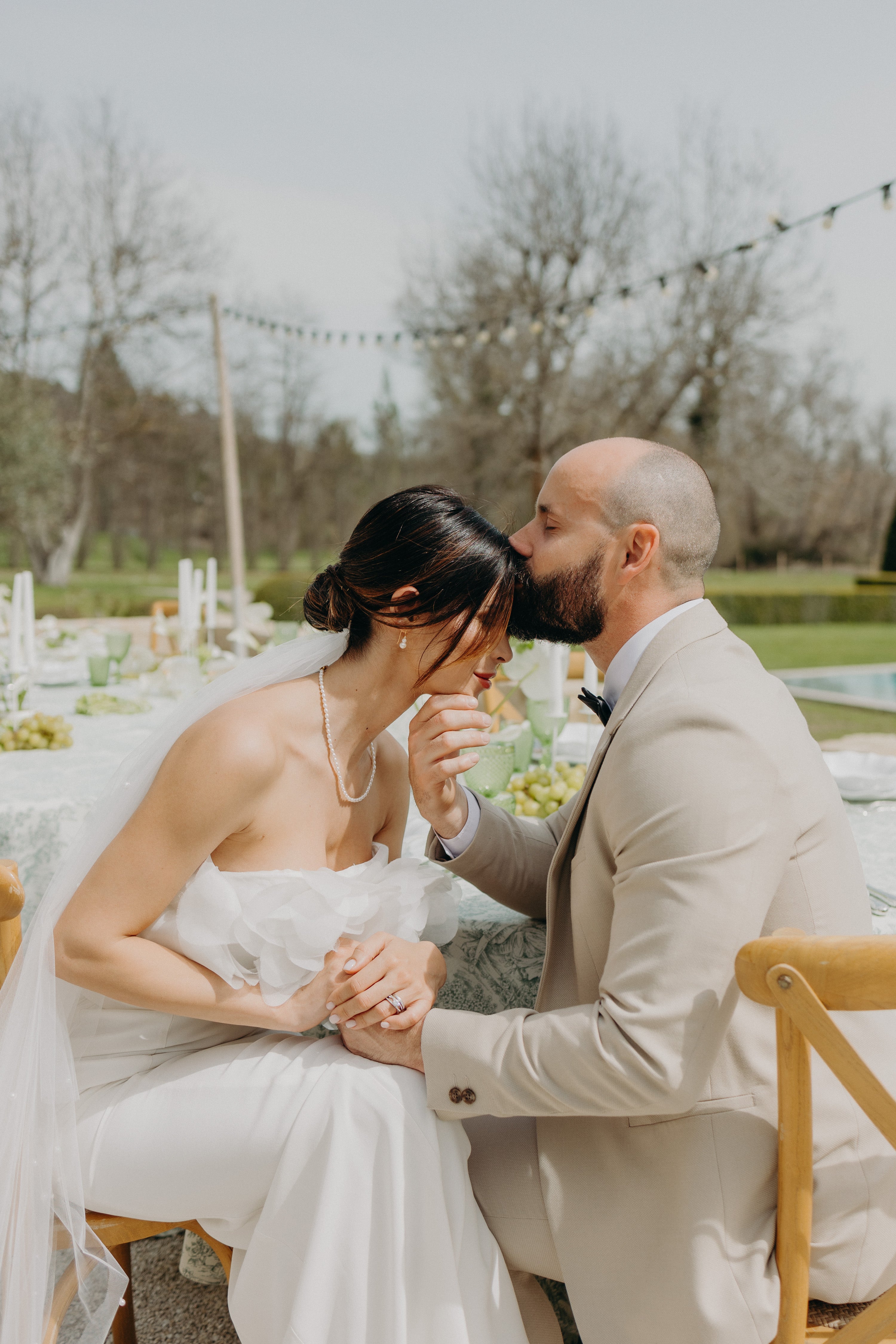 Couple marié romantique, mariage moderne et naturel thème matcha et olive, le marié embrasse le front de sa femme en robe de mariée raffinée. Inspiration mariage thème matcha olive.