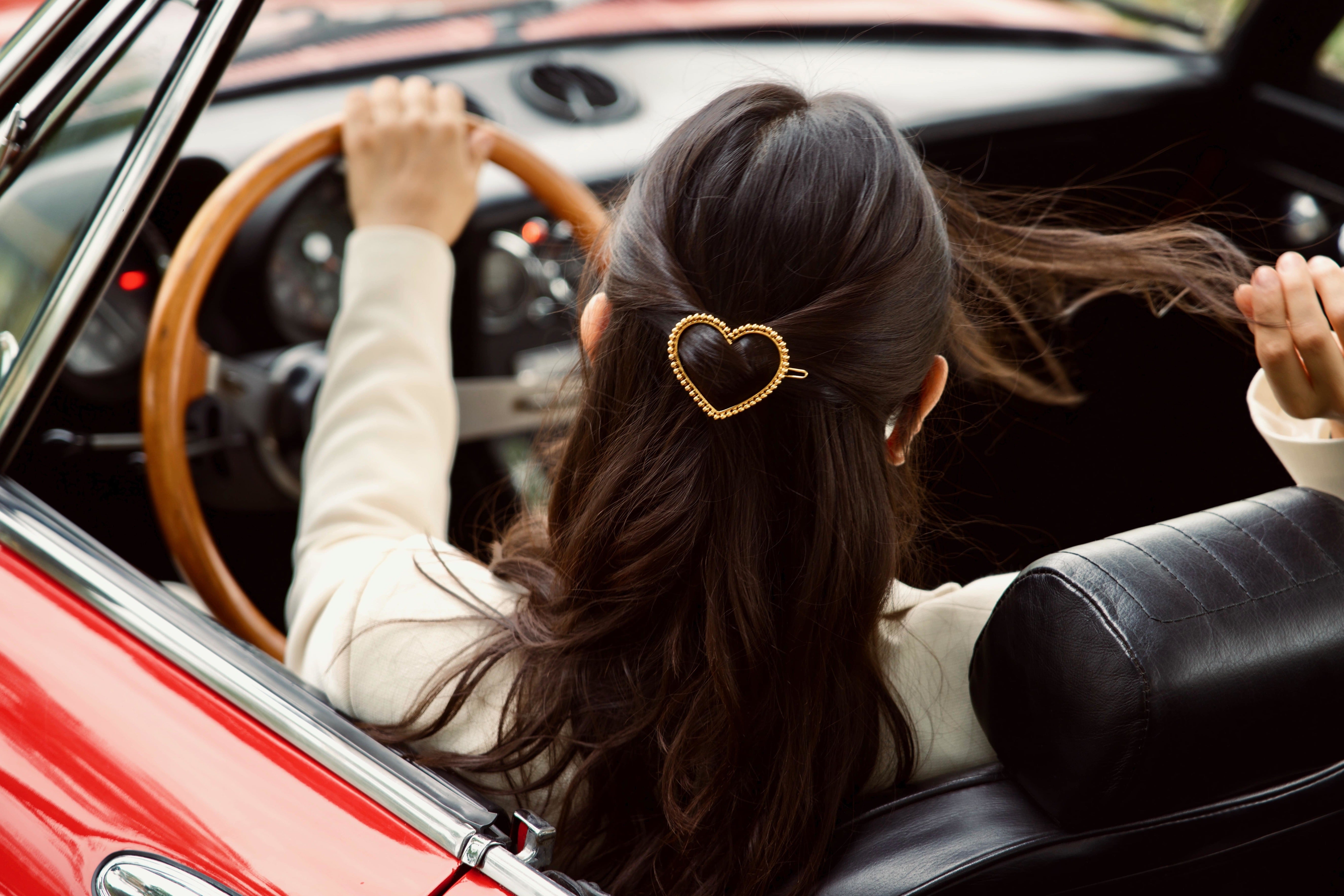 Barrette romantique coeur pour femme au volant d'une voiture rouge
