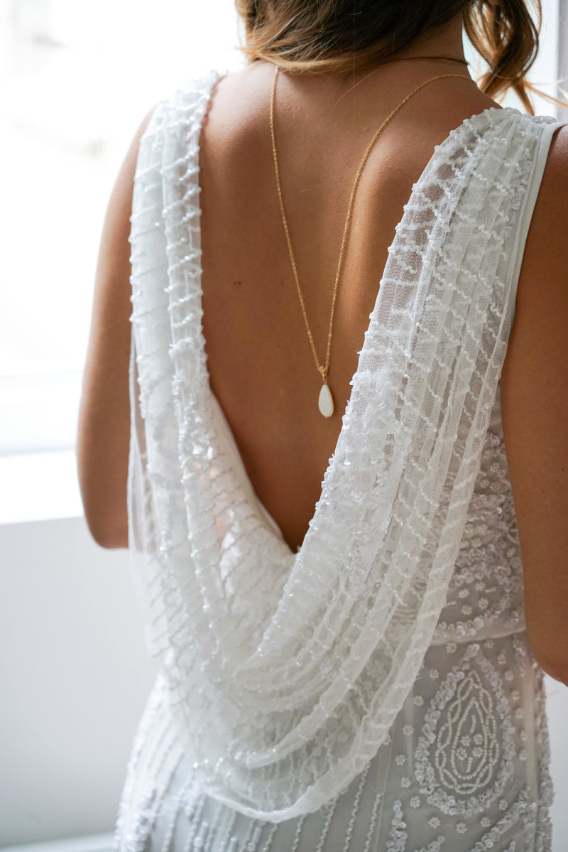Mariée portant un collier de dos avec goutte en perle