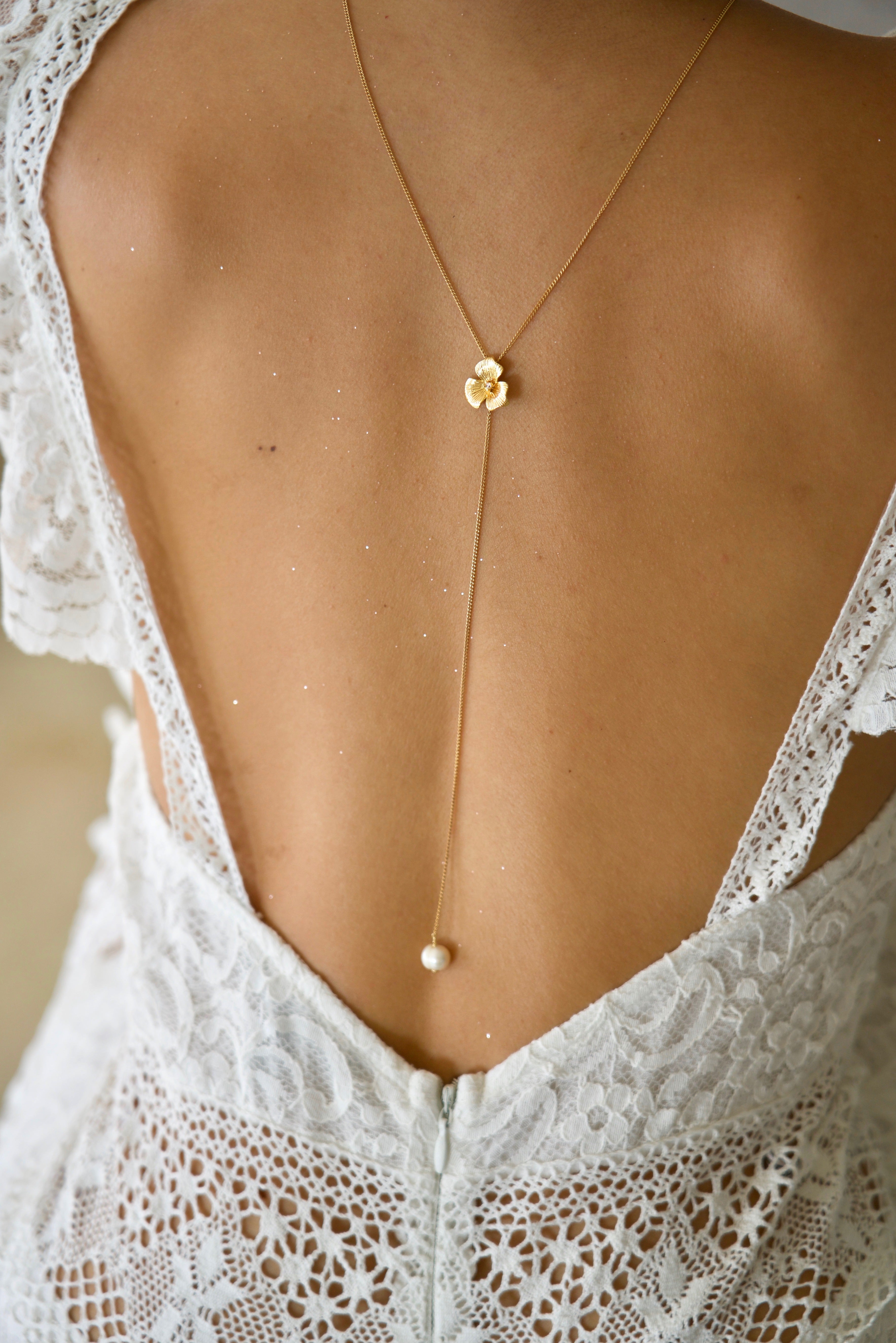 Mariée portant un long collier de dos floral doré