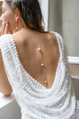 collier de dos pour mariage avec une chaine en or et 3 perles porté par une mariée avec une robe blanche dos nu