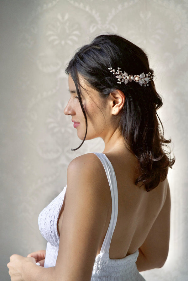 Mariée portant deux pics à cheveux fleuris en or pour une coiffure au style floral et bohème