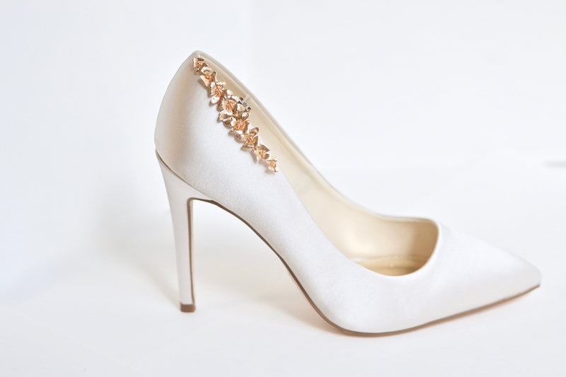 Clip à chaussure doré fleuri sur une chaussure de mariée beige