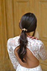 Mariée avec queue-de-cheval basse accessoirisé d'un petit pic à cheveux floral doré