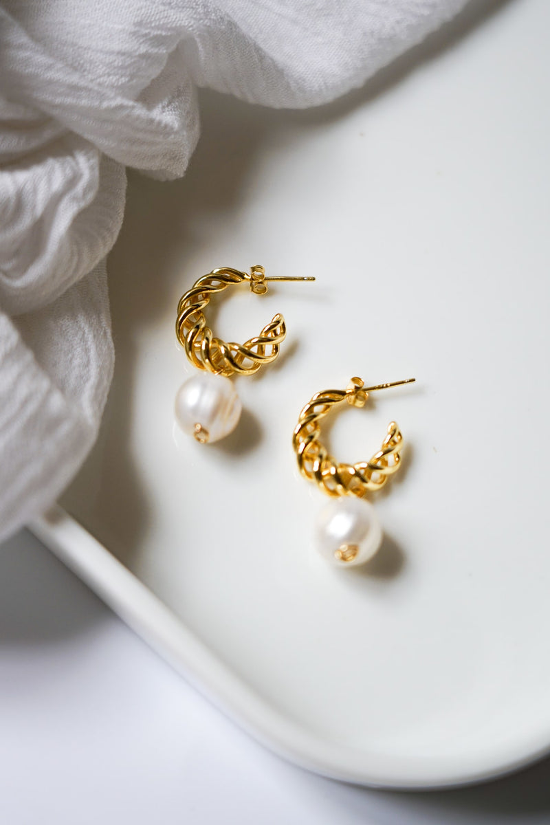 Boucles d'oreilles créoles entrelacées dorée avec une perle