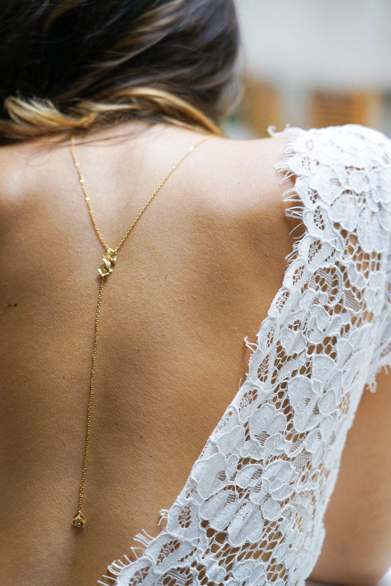 collier de dos en or pour un mariage pris en photo de près