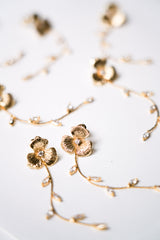 Boucles d'oreilles pendantes fait à la main avec une fleur pour le centre de la boucle et une blanche de feuilles en pendentif