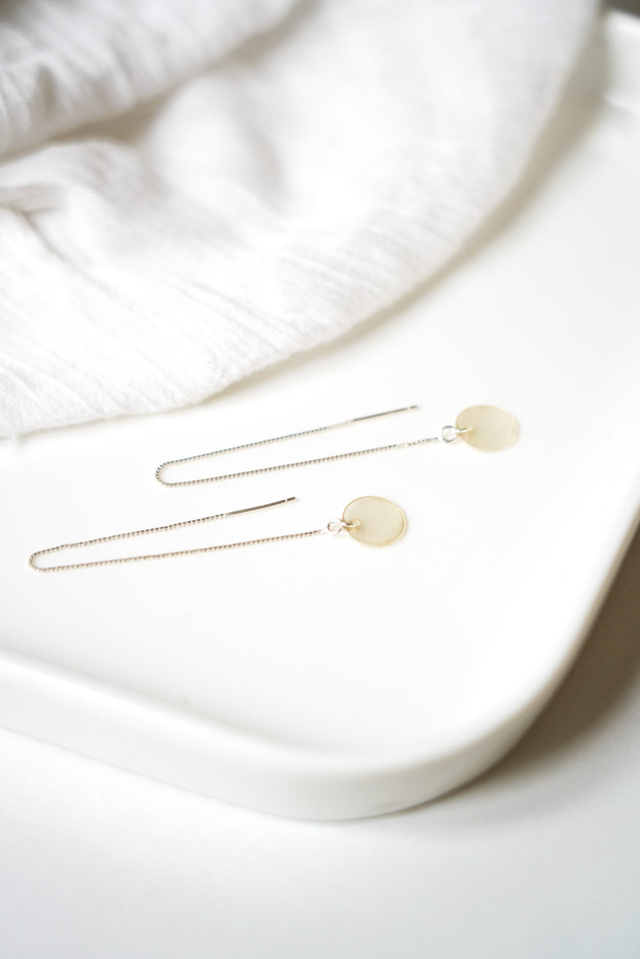 bijoux de mariage boucles d'oreilles posé sur un fond blanc dans le style minimaliste