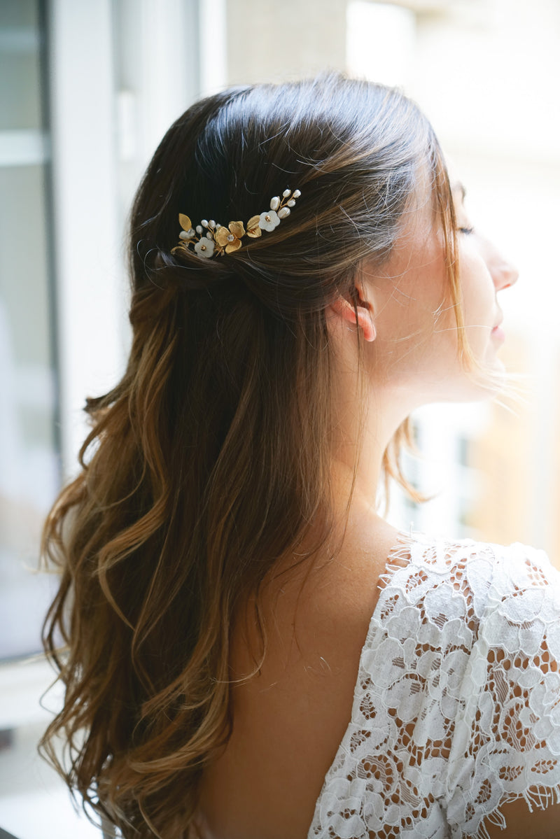pic de cheveux pour mariage thème floral avec des fleurs en or et en nacre avec des branches de perles naturelles porté par la mariée sur cheveux détachés