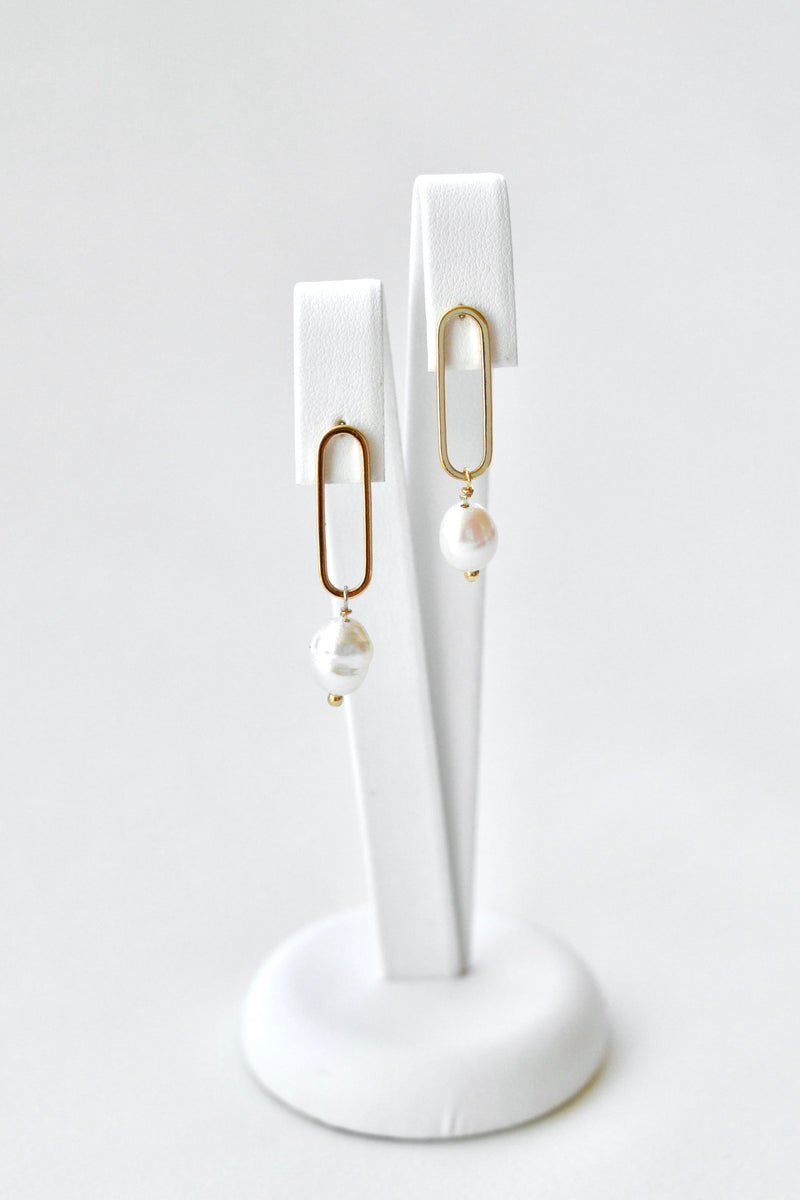boucles d'oreilles de mariage posé sur un portant à bijoux
