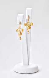 boucles d'oreilles mariage en or veille en forme de fleurs avec un cristal sur un portant à bijoux blanc