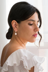 mariée portant des boucles d'oreilles pendante en argent avec une perle naturelle