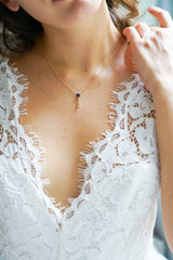 collier pour mariage avec une pierre naturelle bleu porté par une mariée avec une décolleté en dentelle