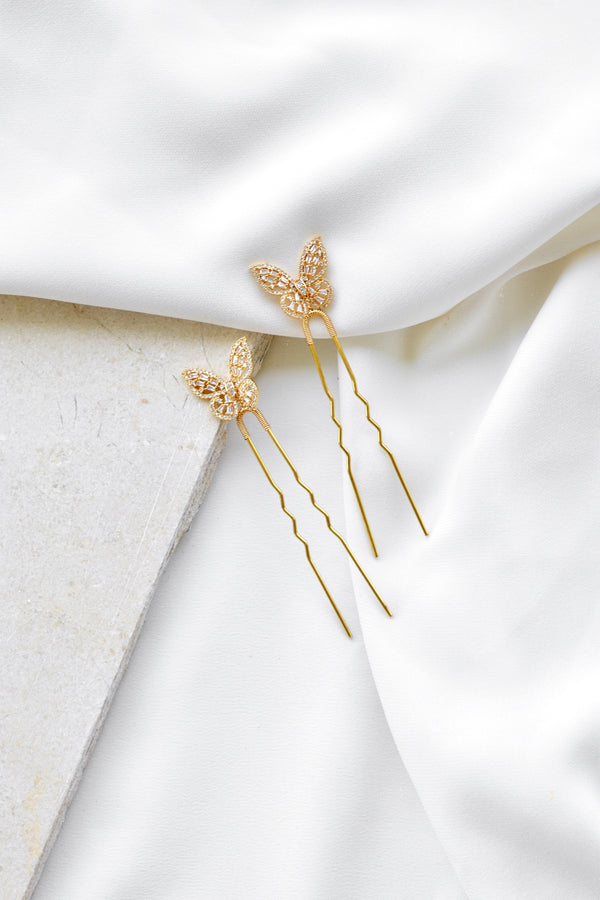 pics pour cheveux mariage en forme de papillon sur un drap blanc