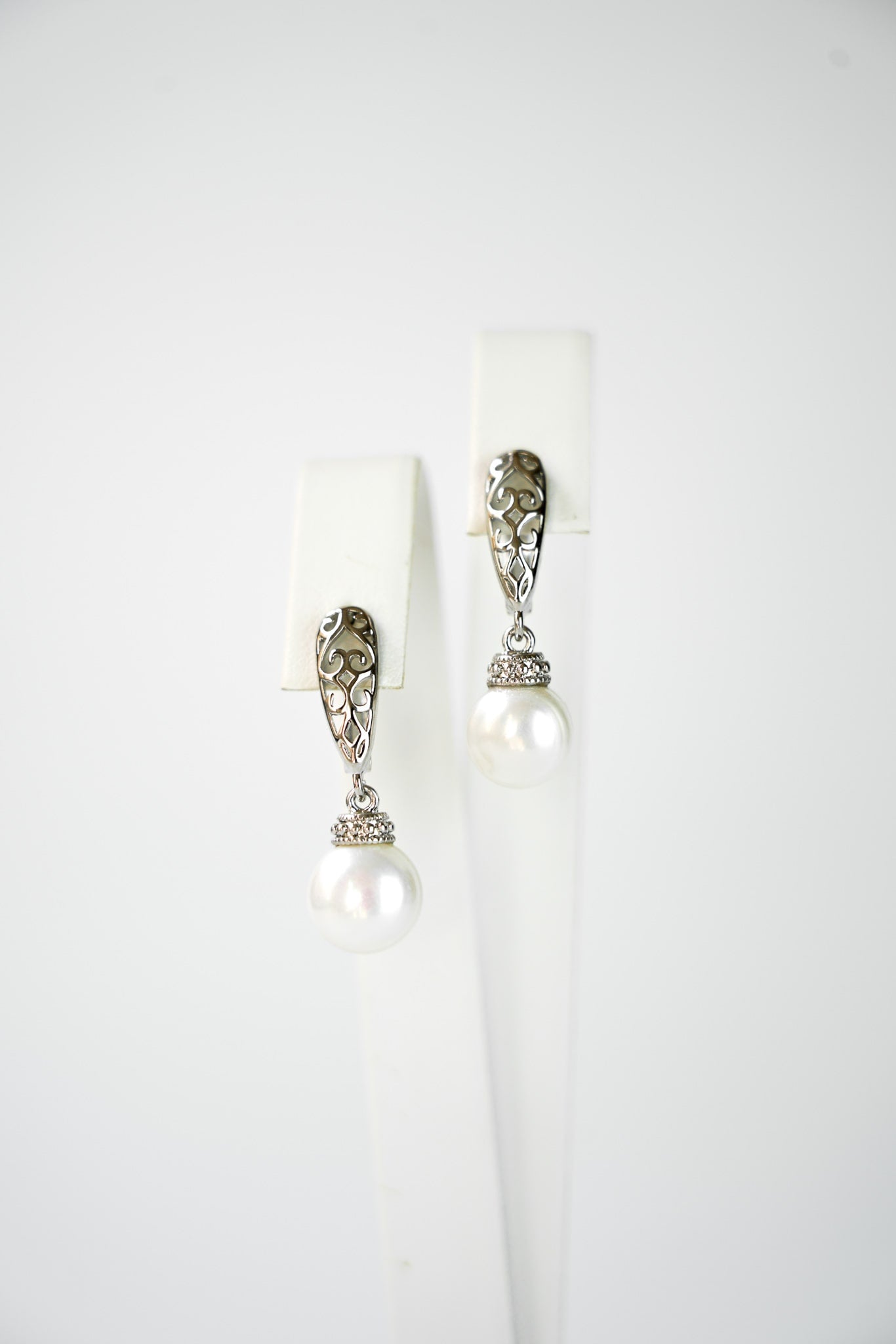 boucles d'oreilles vintage et bohème en argent porté par une mariée avec son collier et sa robe de mariage avec une attache en forme géométrique et une perle en pendentif