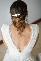coiffure de mariage avec un peigne en nacre sur une mariage en robe blanche avec de la dentelle