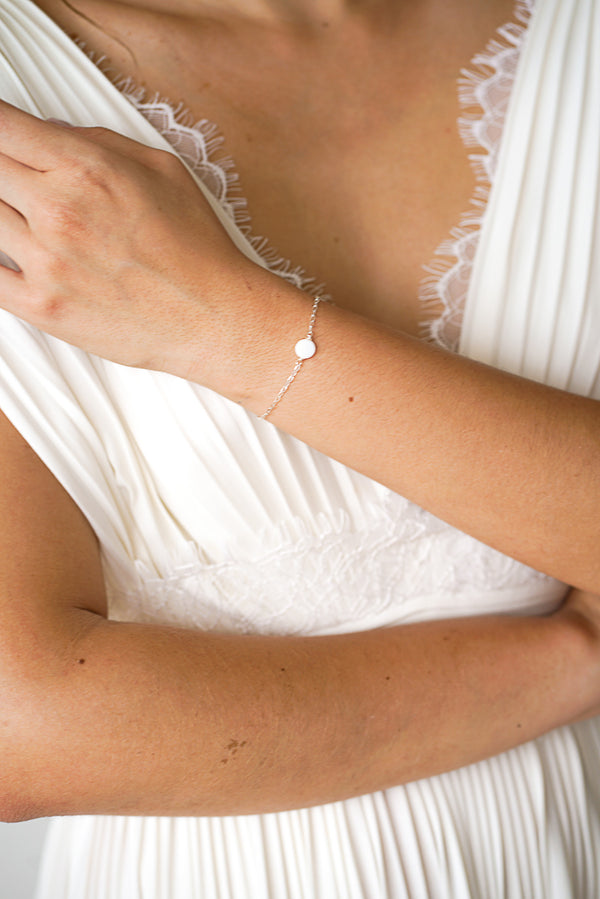 Mariée portant un bracelet argent avec un disque en perle mère élégant