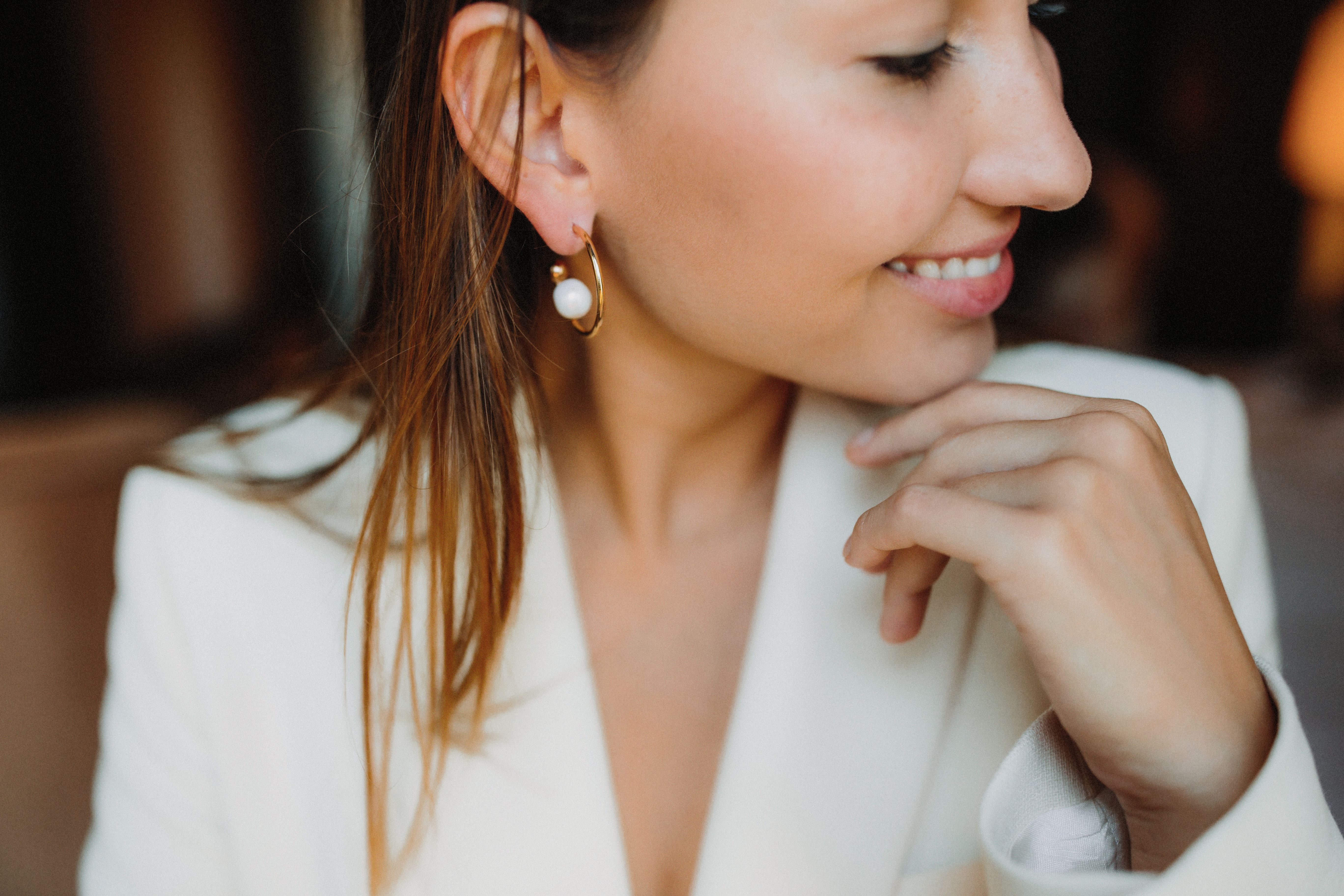 Mariée portant des boucles d'oreilles de mariage créoles dorées avec perle pour mariage civil