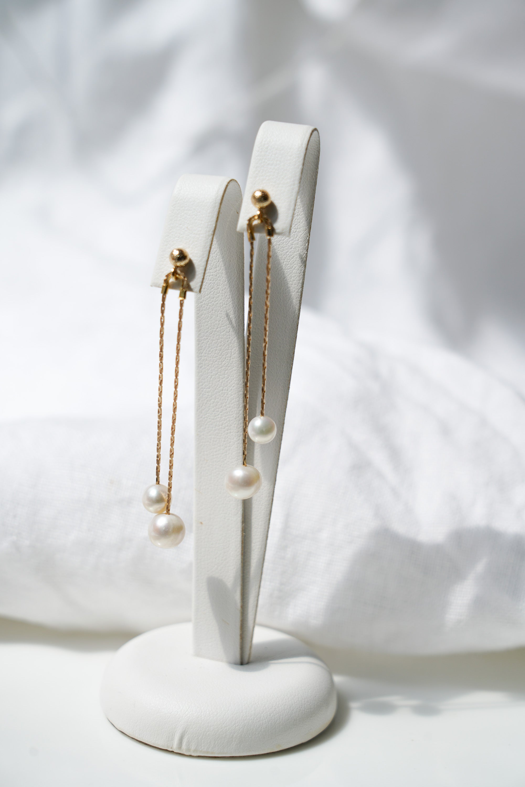 Paire de boucles d'oreilles pendantes dorées à double chaine et deux perles rondes blanches au bout