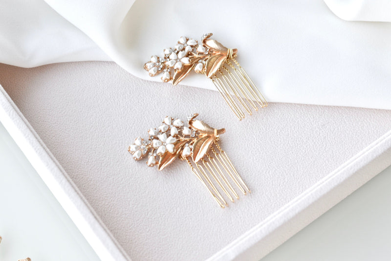 petit peigne de cheveux mariage dans le style floral romantique avec des fleurs blanche et une feuille en or sur un fond blanc en satin 