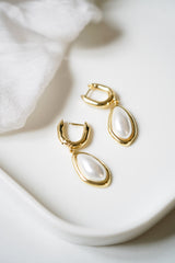 boucles d'oreilles minimaliste avec une perles naturelles imparfaites sur un fond blanc
