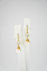 boucles d'oreilles pour mariage avec un cristaux et une perle en pendentif sur un socle de bijou