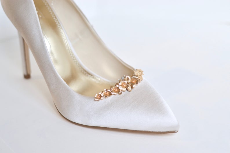 Clip à chaussure à fleurs doré sur une chaussure beige