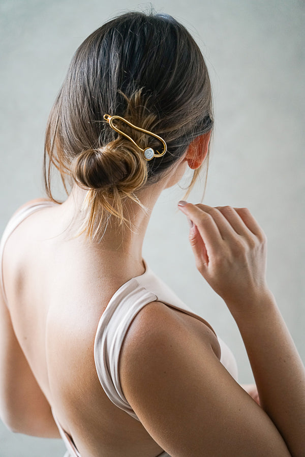 barrette minimaliste au style moderne en or avec un cristal brillant sur un chignon pour la demoiselle d'honneur