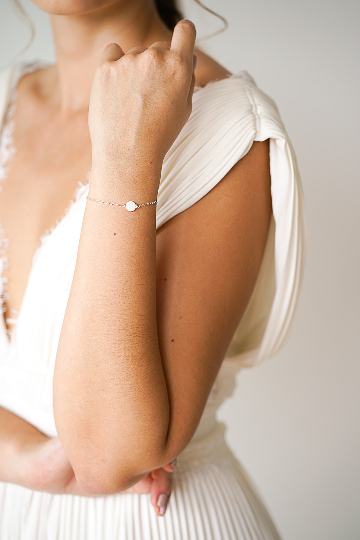 Mariée portant un bracelet argent avec un disque en perle mère minimaliste