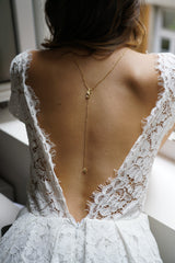 collier de dos esprit floral en or porté par une mariée en robe dos nu