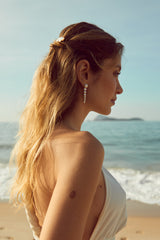 mariée sur la plage avec des boucles d'oreilles faite à la main en perle naturelle