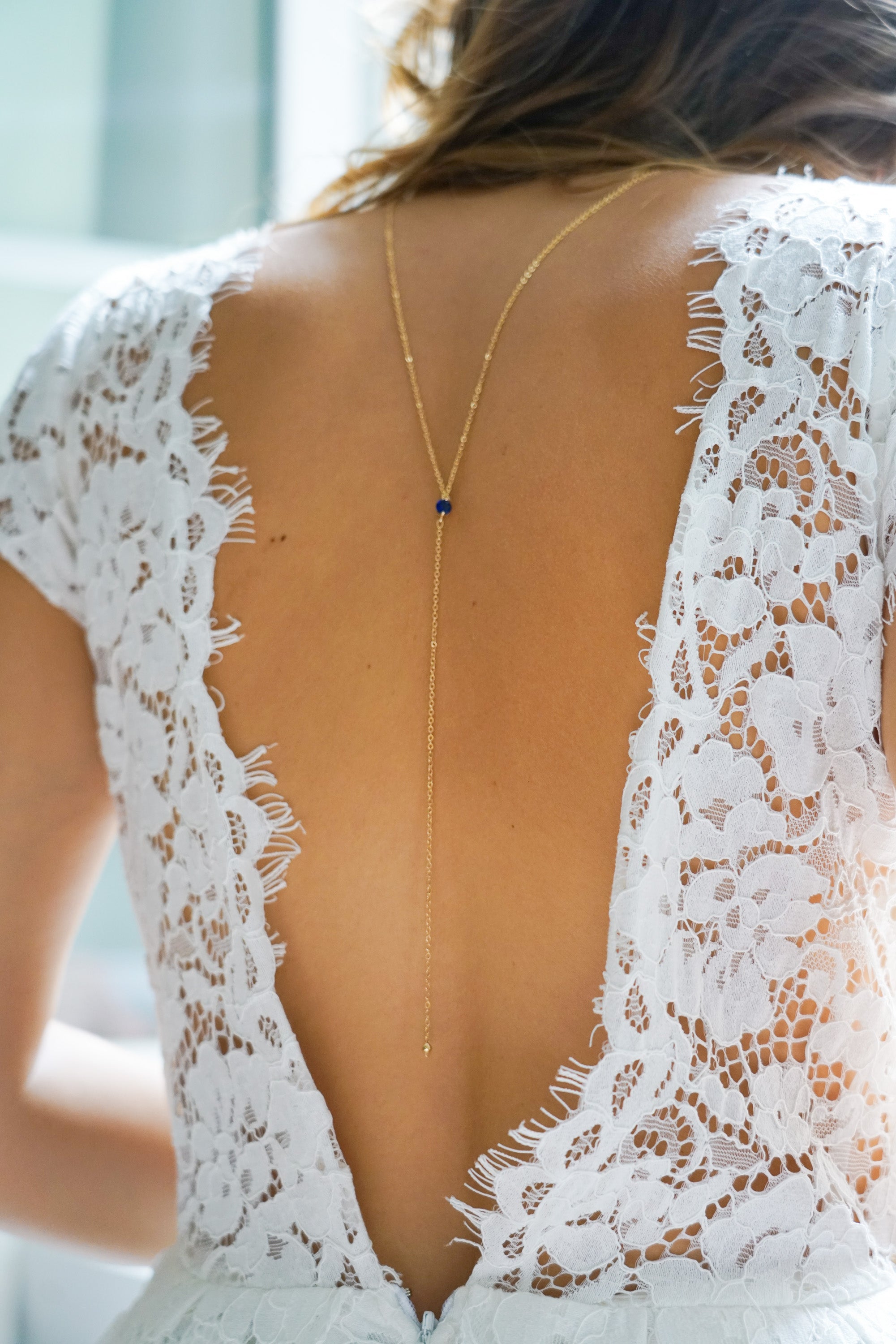 collier de dos pour mariage avec une pierre naturelle bleu avec un décolleté de dos en dentelle