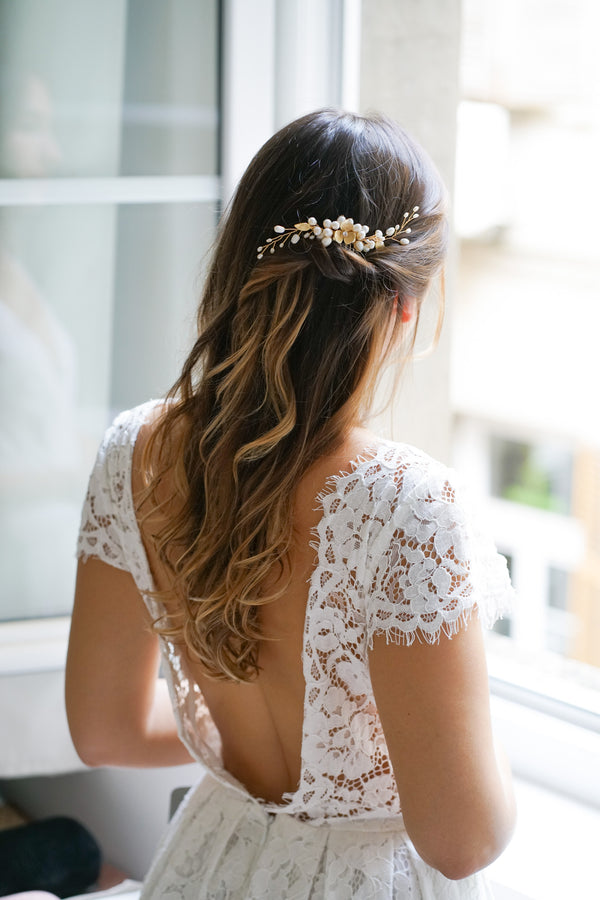 Mariée portant un peigne de mariée bohème à fleurs dorées et perles