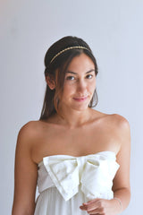 demoiselle d'honneur de la mariée en robe avec un noeud portant un headband en or à petite maille