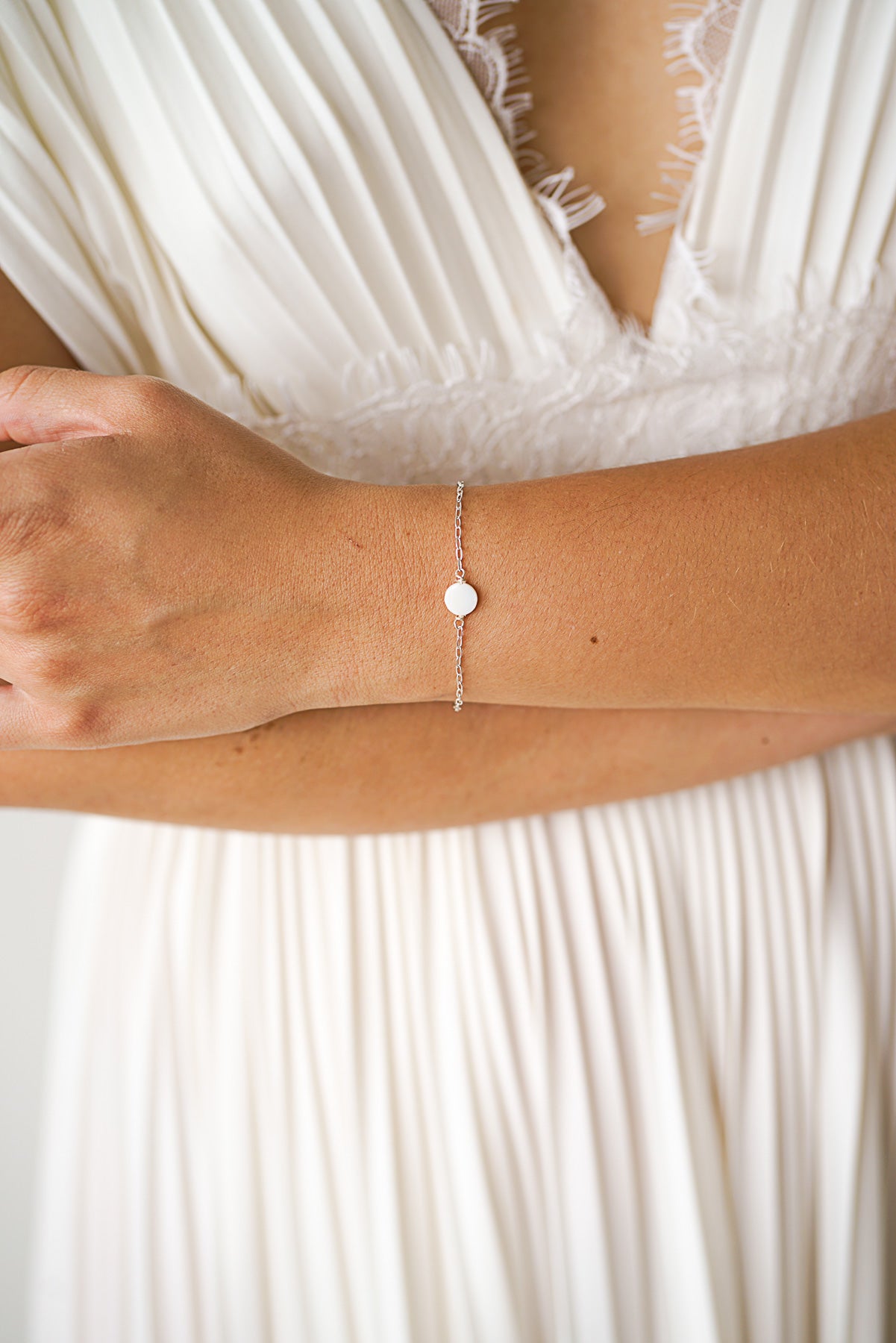 Mariée portant un bracelet argent avec un disque en perle mère moderne