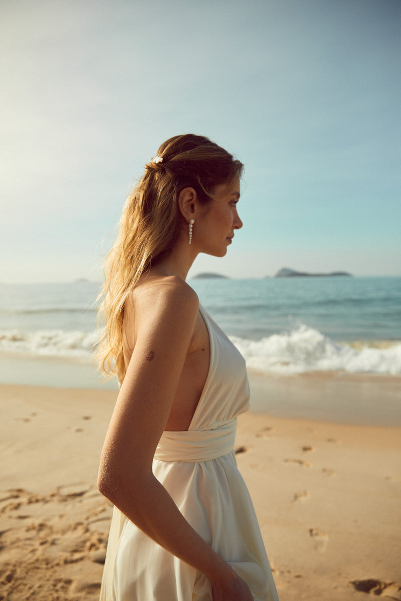 boucles d'oreilles faite à la main en perle naturelle porté par une mariée sur la plage