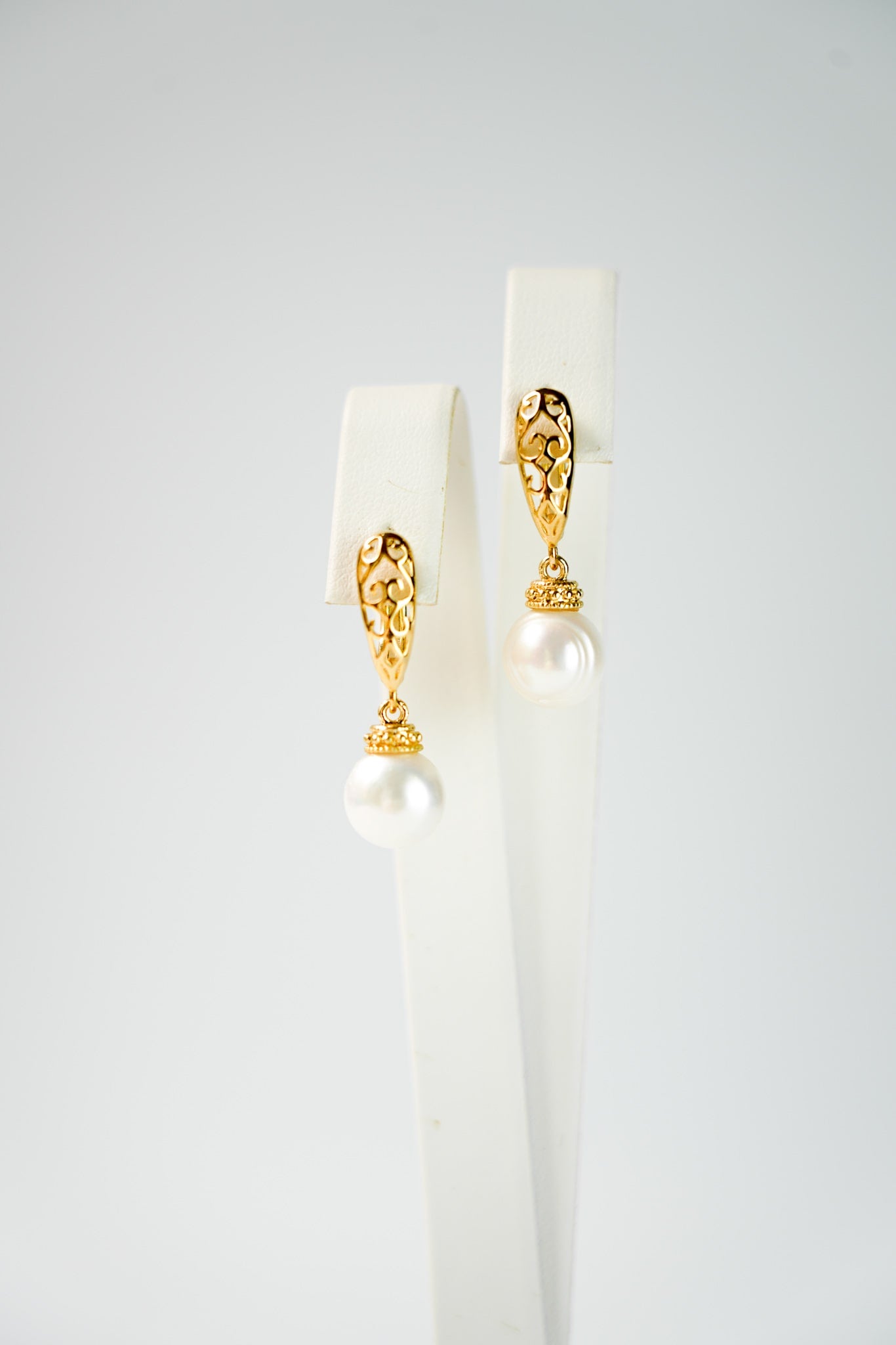 boucles d'oreilles vintage et bohème en or avec une perle naturelle et une attache avec des formes géométrique