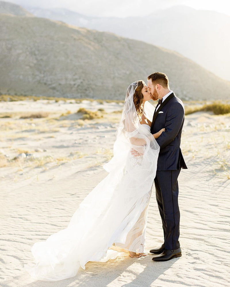 Couple de mariée s'embrassant sur le sable, inspiration mariage bohème