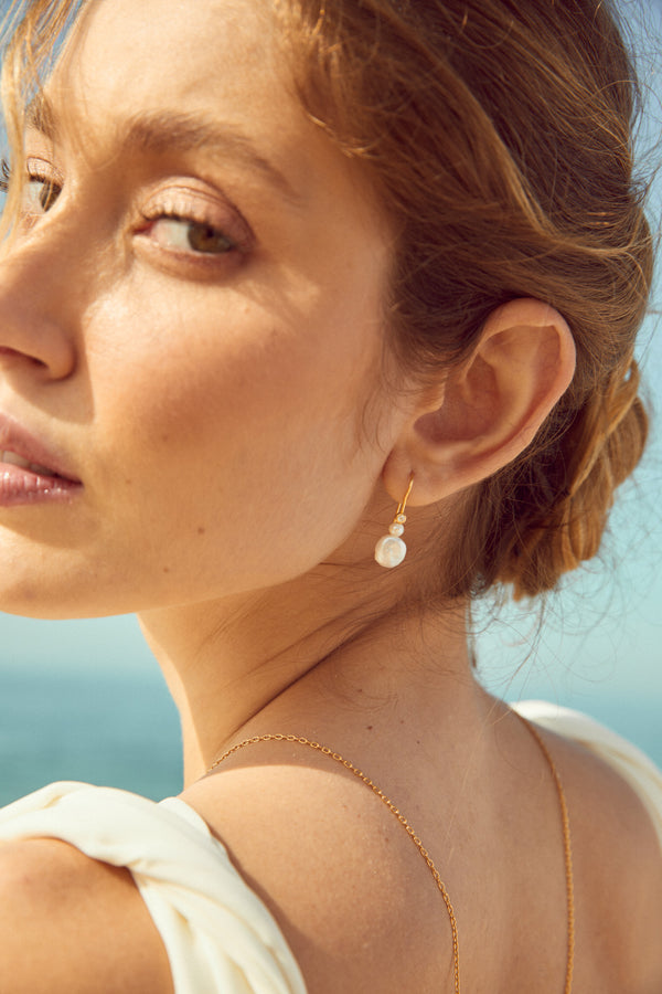 Femme portant des boucles d'oreilles en perles simple 