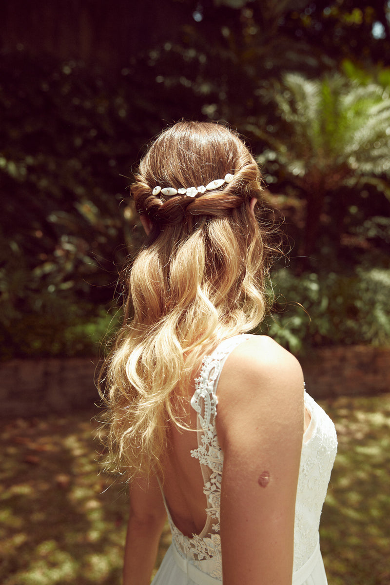 Mariée portant une vigne à cheveux florale blanche en nacre