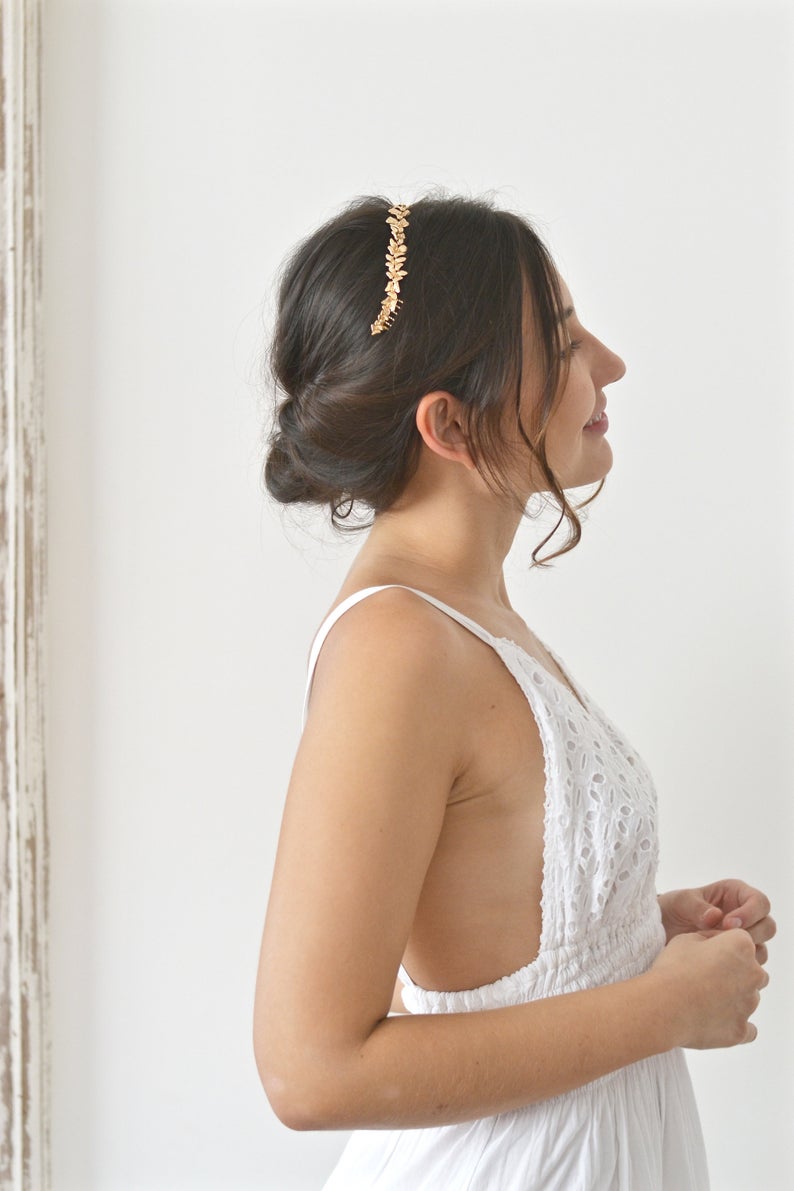 mariée en robe blanche à dentelle portant un headband de fleurs en or