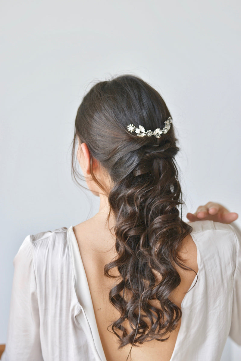 Mariée portant une vigne à cheveux florale à cristaux sur une coiffure de mariée semi attachée