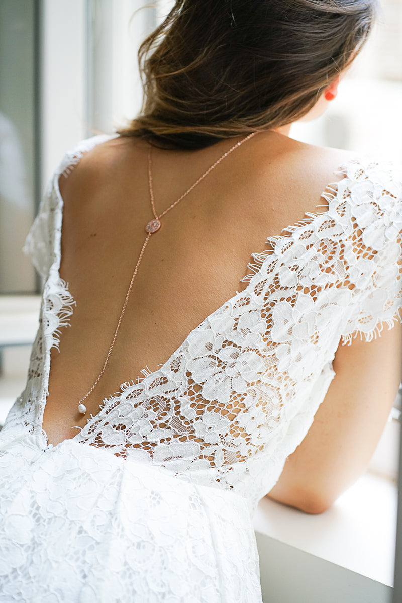 collier de dos porté par une mariée romantique avec une robe en dentelle et un décolleté de dos