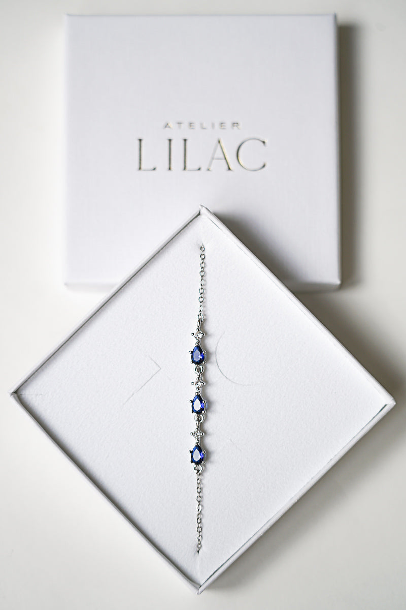 Bracelet de mariée en argent orné de cristaux et de pierres bleues dans une boite Atelier Lilac blanche