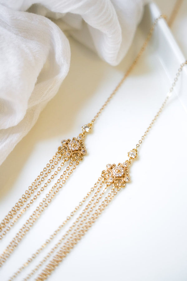 collier de dos romantique avec plusieurs étages de chaines en or et deux connecteurs en or