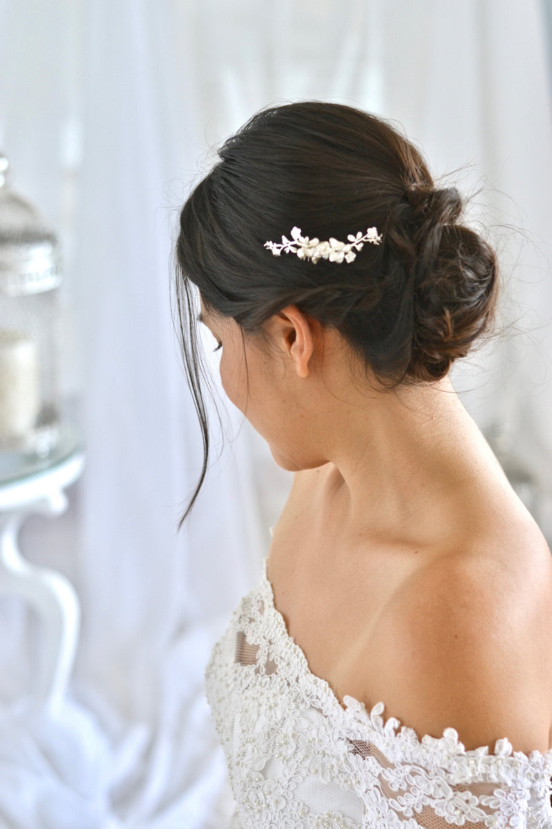 coiffure de mariée en chignon avec un peigne de mariage en argent avec des fleurs et des perles