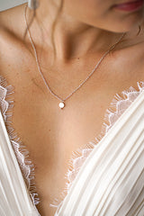 Mariée portant un collier argent avec un disque en perle mère minimaliste