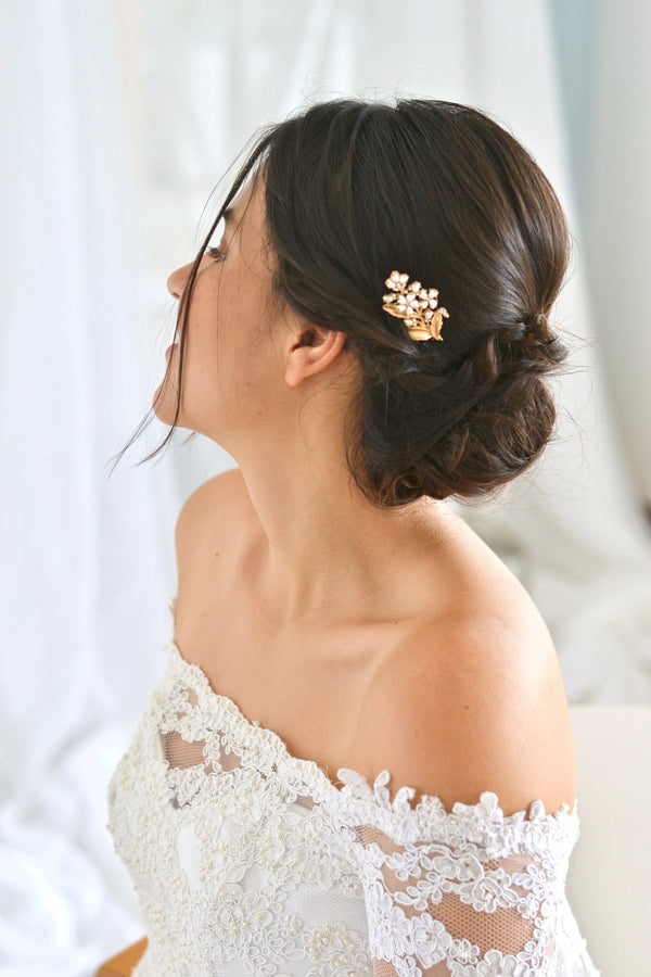 petit peigne de cheveux mariage dans le style floral romantique avec des fleurs blanche et une feuille en or 